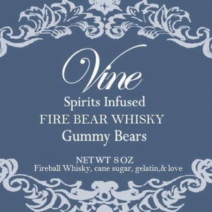 May include: A blue label with white text and decorative flourishes. The label reads "Vine Spirits Infused FIRE BEAR WHISKY Gummy Bears NET WT 8 OZ Fireball Whisky, cane sugar, gelatin, & love".
