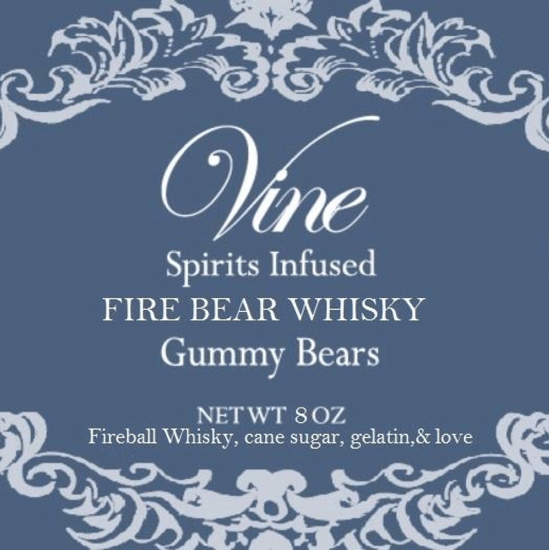 May include: A blue label with white text and decorative flourishes. The label reads "Vine Spirits Infused FIRE BEAR WHISKY Gummy Bears NET WT 8 OZ Fireball Whisky, cane sugar, gelatin, & love".