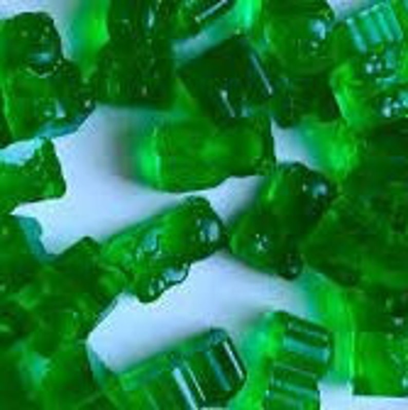 May include: Assortment of green gummy sweets in various shapes, including bears, cars, and rectangles.