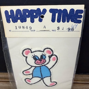 May include: A vintage "Happy Time" iron-on patch featuring a cartoon bear with white fur, pink ears and paws, blue shorts, and a smiling face. The patch is on a white backing with a price tag.
