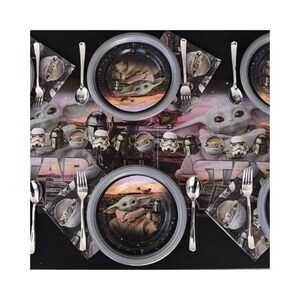 May include: A Star Wars-themed party table setting with plates, napkins, and cutlery. The plates feature an image of Grogu, also known as Baby Yoda, with a silver rim. Napkins and a table runner display Star Wars characters.