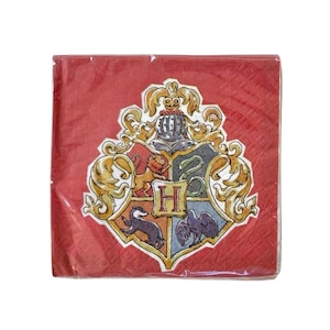 May include: A package of red paper napkins featuring the Hogwarts crest. The crest is a detailed emblem with a shield divided into four sections, each with a different animal and color, and the letter "H" in the center.
