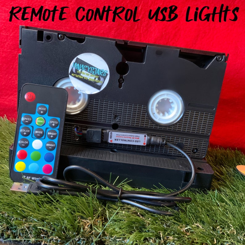 May include: A black VHS cassette tape with a USB cable and a remote control. The remote control has buttons for speed, mode, color, and brightness. The text "LED CONTROLLER" is printed on the USB cable.