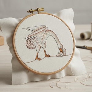 Könnte beinhalten: Gesticktes Kunstwerk in einem Holzrahmen, das eine Gans in Braun- und Beigetönen zeigt, die nach Eiern greift. Das Kunstwerk befindet sich auf cremefarbenem Stoff und ist auf weißem Stoff befestigt. Der Rahmen wird von einem Messingverschluss gehalten.