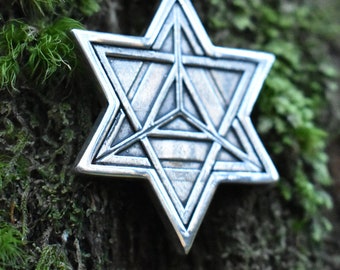 May include: A silver pendant necklace featuring a detailed six-pointed star design. The star is made of multiple overlapping triangles, creating a complex geometric pattern.