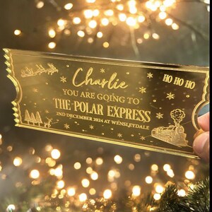 Pode incluir: Bilhete de acr&iacute;lico dourado com glitter para o Expresso Polar com o texto "HO HO HO", "Charlie", "YOU ARE GOING TO THE POLAR EXPRESS" e "2ND DECEMBER 2024 AT WENSLEYDALE".