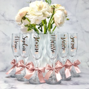 Personalized Champagne Flutes. These flutes feature Metallic Rose Gold font with Rose Gold bows. Font Style #5. Perfect for Bridesmaid Proposals, Birthdays, Weddings, and Special Events