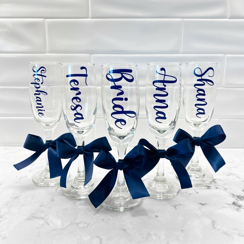 Personalized Champagne Flutes. These flutes feature Navy font with Navy bows. Font Style #7. Perfect for Bridesmaid Proposals, Birthdays, Weddings, and Special Events