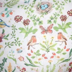 Könnte beinhalten: Ein weißer Hintergrund mit einem sich wiederholenden Muster aus Rotkehlchen, Blaumeisen, Schmetterlingen und Blumen. Das Muster ist ein skurriles und farbenfrohes Design.