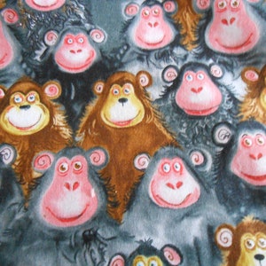 Puede incluir: Un patrón de tela con un diseño repetitivo de monos de dibujos animados. Los monos tienen caras rosas, pelaje marrón y gris, y están sonriendo. El fondo es una mezcla de gris y marrón.