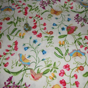 Könnte beinhalten: Weißer Stoff mit einem sich wiederholenden Muster aus grünen Ranken, rosa und weißen Blüten und bunten Schmetterlingen.