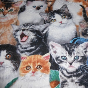 Op de afbeelding: Een kleurrijke stof met een patroon van meerdere katten. De katten zijn in verschillende poses, waaronder zittend, staand en liggend. De stof is een mix van bruin, wit, zwart en grijs.