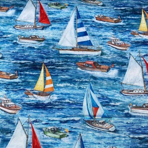 Op de afbeelding: Een nautisch patroon met zeilboten en motorboten op een blauwe, getextureerde zee. De zeilboten hebben kleurrijke zeilen in rood, geel en wit. De motorboten zijn bruin en wit.