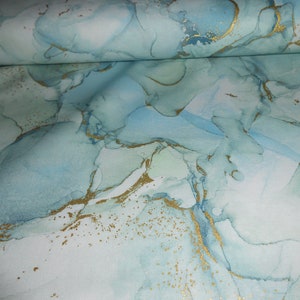 Könnte beinhalten: Abstrakter Stoff mit einem blauen und weißen Marmormuster und goldenen Akzenten.