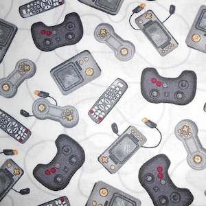 Può includere: Tessuto bianco con un motivo di vari controller di videogiochi, console portatili e telecomandi grigi e neri. I controller hanno pulsanti rossi e gialli. Il design è adatto a giocatori e appassionati di tecnologia.
