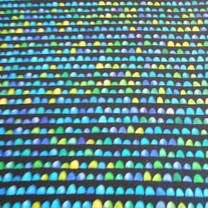 Könnte beinhalten: Ein schwarzer Stoff mit einem sich wiederholenden Muster aus kleinen, blauen, grünen und gelben Halbkreisen.