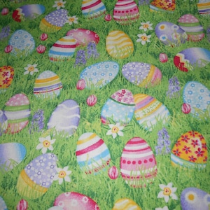 Könnte beinhalten: Ein grüner Stoff mit einem sich wiederholenden Muster aus bunten Ostereiern. Die Eier sind mit verschiedenen Mustern verziert, darunter Streifen, Punkte und Blumenmuster.