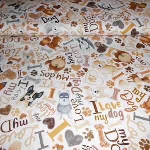 Könnte beinhalten: Weißer Stoff mit einem sich wiederholenden Muster aus braunen und grauen Hunden, Pfotenabdrücken, Knochen und Herzen. Der Text "I Love My Dog" wird auf dem gesamten Stoff wiederholt.