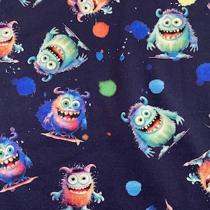 Può includere: Tessuto blu navy con un motivo ripetuto di mostri dei cartoni animati in vari colori, tra cui blu, verde, arancione e viola. I mostri sorridono e sembrano fare surf su piccole tavole. Schizzi di vernice colorati sono sparsi sullo sfondo.