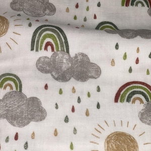Può includere: Tessuto bianco con un motivo ripetuto di arcobaleni, nuvole, gocce di pioggia e soli. Gli arcobaleni sono verdi, rossi e marroni. Le nuvole sono grigie. Le gocce di pioggia sono verdi, marroni e dorate. I soli sono dorati.