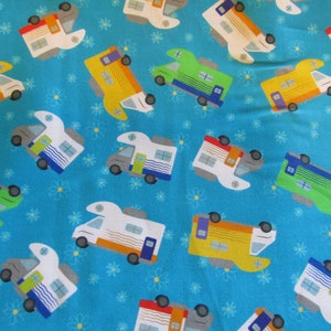 Op de afbeelding: Een blauwe stof met een herhalend patroon van kleurrijke campers. De campers zijn in verschillende kleuren, waaronder groen, geel, rood en wit. De campers hebben witte ramen en blauwe bekleding. De stof heeft een wit madeliefjepatroon.