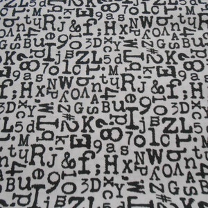 Könnte beinhalten: Ein weißer Stoff mit einem schwarz-weißen Muster aus Buchstaben und Zahlen. Die Buchstaben und Zahlen sind in einer Schreibmaschinenschrift gedruckt.