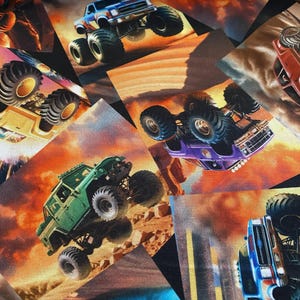 Peut inclure: Tissu présentant un collage de monster trucks en action sur fond de coucher de soleil flamboyant. Les camions sont représentés en différentes couleurs, dont le vert, le bleu et le violet, avec des pneus surdimensionnés et des motifs détaillés. Le thème général est la course à indice d'octane élevé.