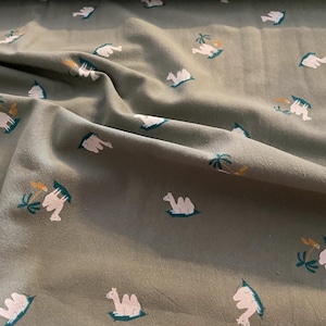 Tessuto rustico in cotone 100% con cammelli su sfondo oliva Katia 50 x 130 cm