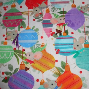May include: A white fabric with a repeating pattern of colorful Christmas ornaments and mice. The ornaments are striped and have a variety of colors, including red, green, blue, yellow, and orange. The mice are white with gray accents and are holding onto the ornaments.