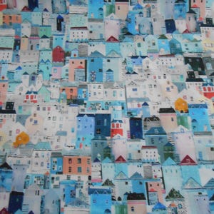 Op de afbeelding: Een kleurrijke stofdruk met een herhalend patroon van kleine, gestileerde huizen in tinten blauw, groen, roze, geel en wit. De huizen zijn in een willekeurig patroon gerangschikt, wat een grillig en charmant ontwerp creëert.