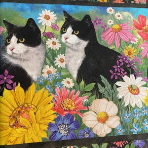 May include: A fabric design showcasing two black and white cats surrounded by a colourful garden. The floral arrangement includes sunflowers, daisies, and other blooms in yellow, pink, purple, and blue, set against a blue sky.