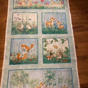 Può includere: Un pannello di tessuto con sei scene illustrate di animali del bosco. Le scene raffigurano conigli, cervi, volpi, scoiattoli e ricci tra fiori e alberi. La tavolozza dei colori è tenue, con blu, verdi e toni della terra.