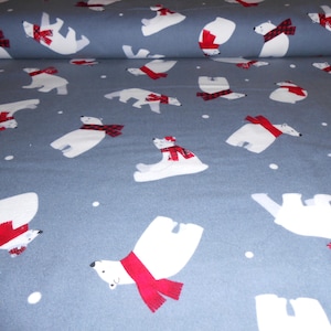 May include: A roll of blue fabric featuring a repeating pattern of white polar bears wearing red plaid scarves. The bears are in various poses, with small white dots scattered across the fabric.