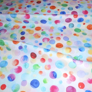 Könnte beinhalten: Weißer Stoff mit einem bunten Aquarell-Polka-Dot-Muster. Die Punkte sind in verschiedenen Blautönen, Grün-, Gelb-, Orange-, Rosa- und Rottönen.