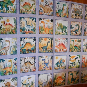 Könnte beinhalten: Ein Stoffpanel mit einem sich wiederholenden Muster aus bunten Dinosauriern in einer Dschungelkulisse. Die Dinosaurier sind in verschiedenen Posen und Farben, darunter Grün, Orange, Rot und Blau. Der Hintergrund ist hellgrau mit einer dezenten Textur.