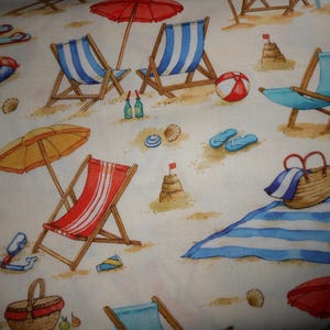 Könnte beinhalten: Ein farbenfroher Strand-Stoff mit Bildern von Strandstühlen, Sonnenschirmen, Strandbällen und einem Picknickkorb. Der Stoff hat einen weißen Hintergrund mit blauen und roten Akzenten.