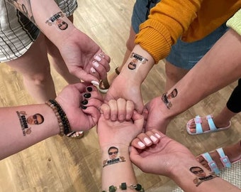 Puede incluir: Un grupo de personas con tatuajes temporales en los brazos. Los tatuajes muestran la cara de un hombre y la palabra "Groom".
