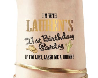 May include: Gold temporary tattoo with the text "I'm with Lauren's 21st Birthday Party" and a lasso design.  The tattoo also includes a cowboy hat and a cactus.