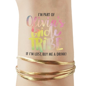 May include: A temporary tattoo with a watercolor design that says "I'm part of Olivia's Bride Tribe. If I'm lost, buy me a drink!"