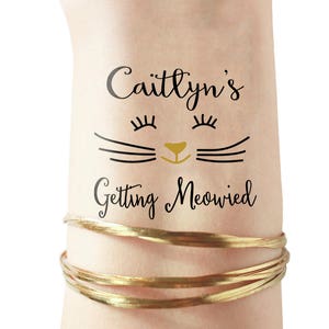 Puede incluir: Un tatuaje temporal con una cara de gato negro y el texto "Caitlynn's Getting Meowed" en letra negra.