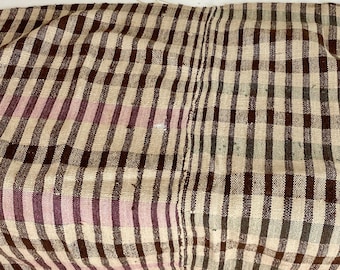 May include: A brown, beige, and green plaid throw blanket with a pink stripe. The blanket is woven and has a rustic, vintage look.