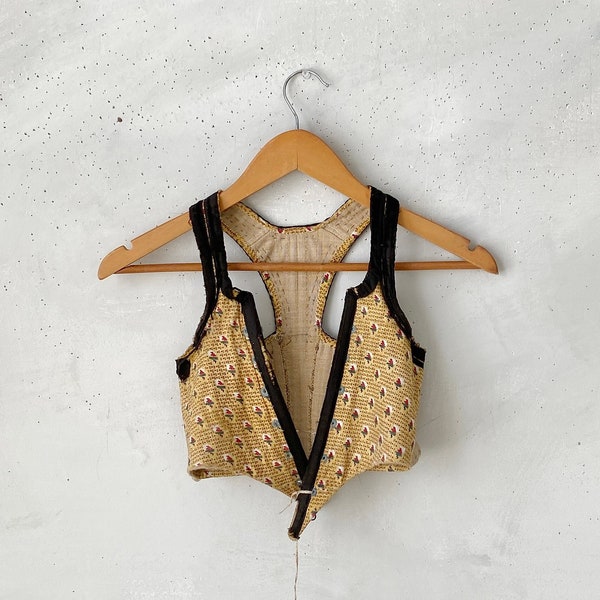 Corsé francés del siglo XVIII. Vestido popular antiguo de 1770 con chaleco floral en la parte trasera. Ropa de trabajo francesa. El baúl textil.