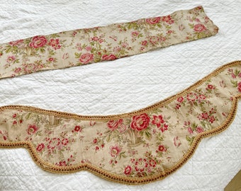 Könnte beinhalten: Zwei Stoffborten mit einem floralen Muster in Rosa-, Grün- und Beigetönen. Die Borte ist gewellt und hat einen goldfarbenen Rand.
