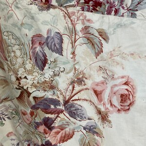 Puede incluir: Una tela blanca con un patr&oacute;n floral que presenta rosas rosas, hojas moradas y flores blancas. La tela tiene una est&eacute;tica vintage.