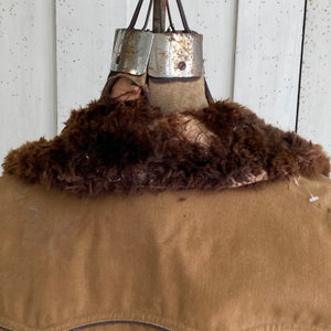 May include: A brown corduroy jacket with a brown faux fur collar. The jacket is on a vintage dress form.