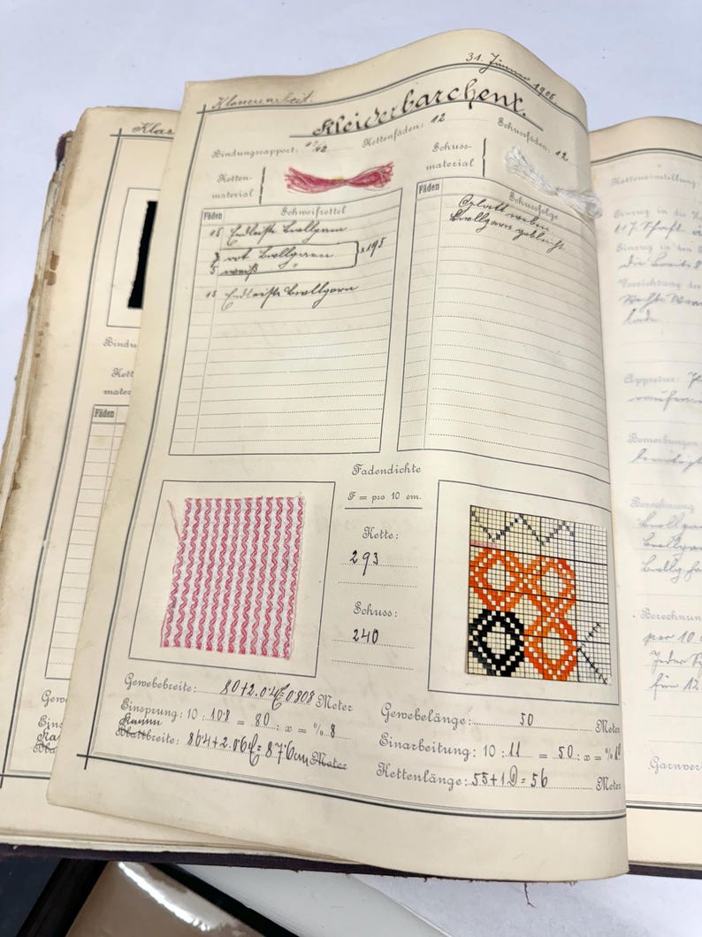 May include: A page from a vintage fabric sample book with a pink and white striped fabric swatch, a black, orange, and white woven fabric swatch, and handwritten text in German. The text includes the date "34. Juni 1921", the word "Fadendichte", and the numbers "293" and "240".