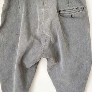 May include: Gray corduroy pants with a single back pocket. The pants have a relaxed fit and a slightly tapered leg.