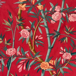 Könnte beinhalten: Ein roter Stoff mit einem floralen Muster mit rosa und gelben Blumen, grünen Blättern und Bambusstangen.
