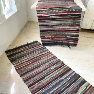 May include: Two colourful rag rugs with a striped pattern. The rugs are made from recycled fabric and have a rustic, vintage look.