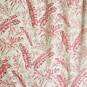 May include: A white fabric with a red tropical leaf pattern. The leaves are stylised and have a vintage look.